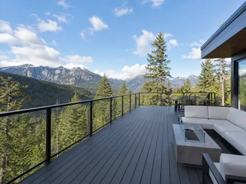 Dark grey deck with glass railing and a mountain view